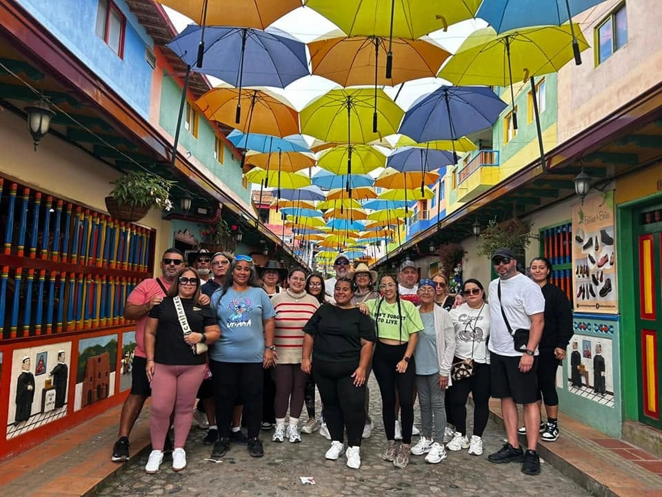 Grupo de viajeros en calle de paraguas en Guatapé