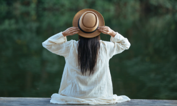 Viajera sola con sombrero contemplando un paisaje natural